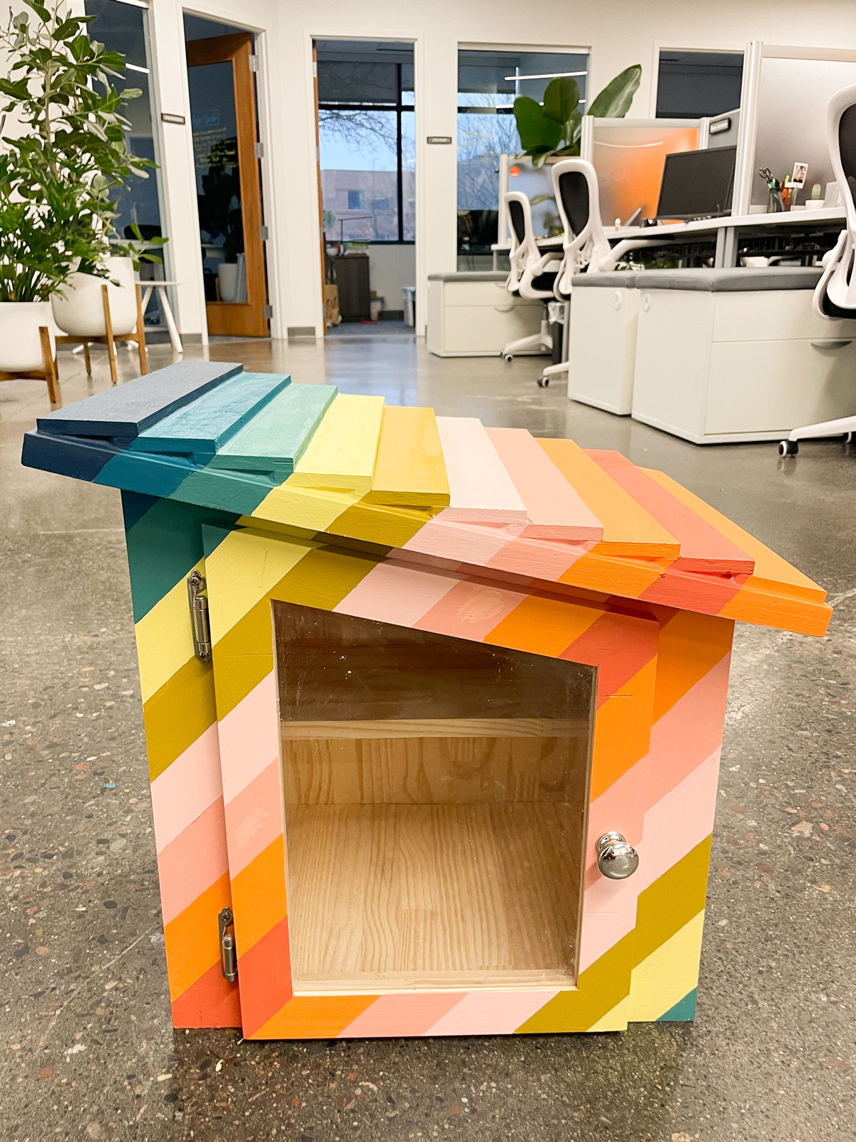 A stripy colorfully painted free little library!